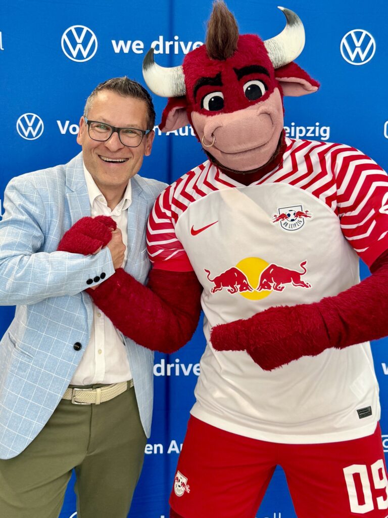 Event Moderator Gerd Edler bei Volkswagen in Leipzig mit Red Bull Maskotchen